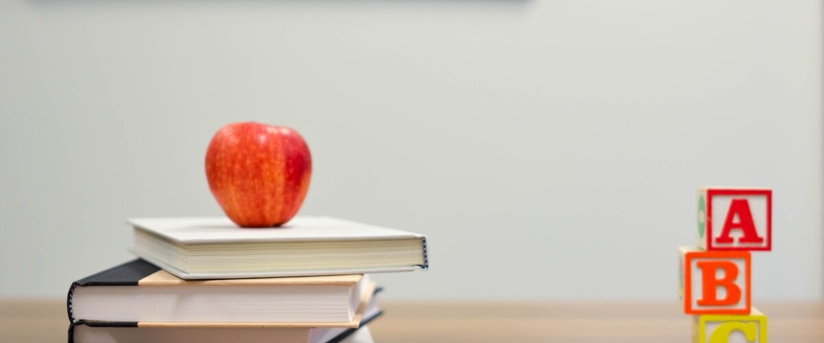 books, pencils and an apple