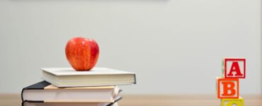 books, pencils and an apple