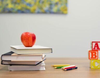 books, pencils and an apple